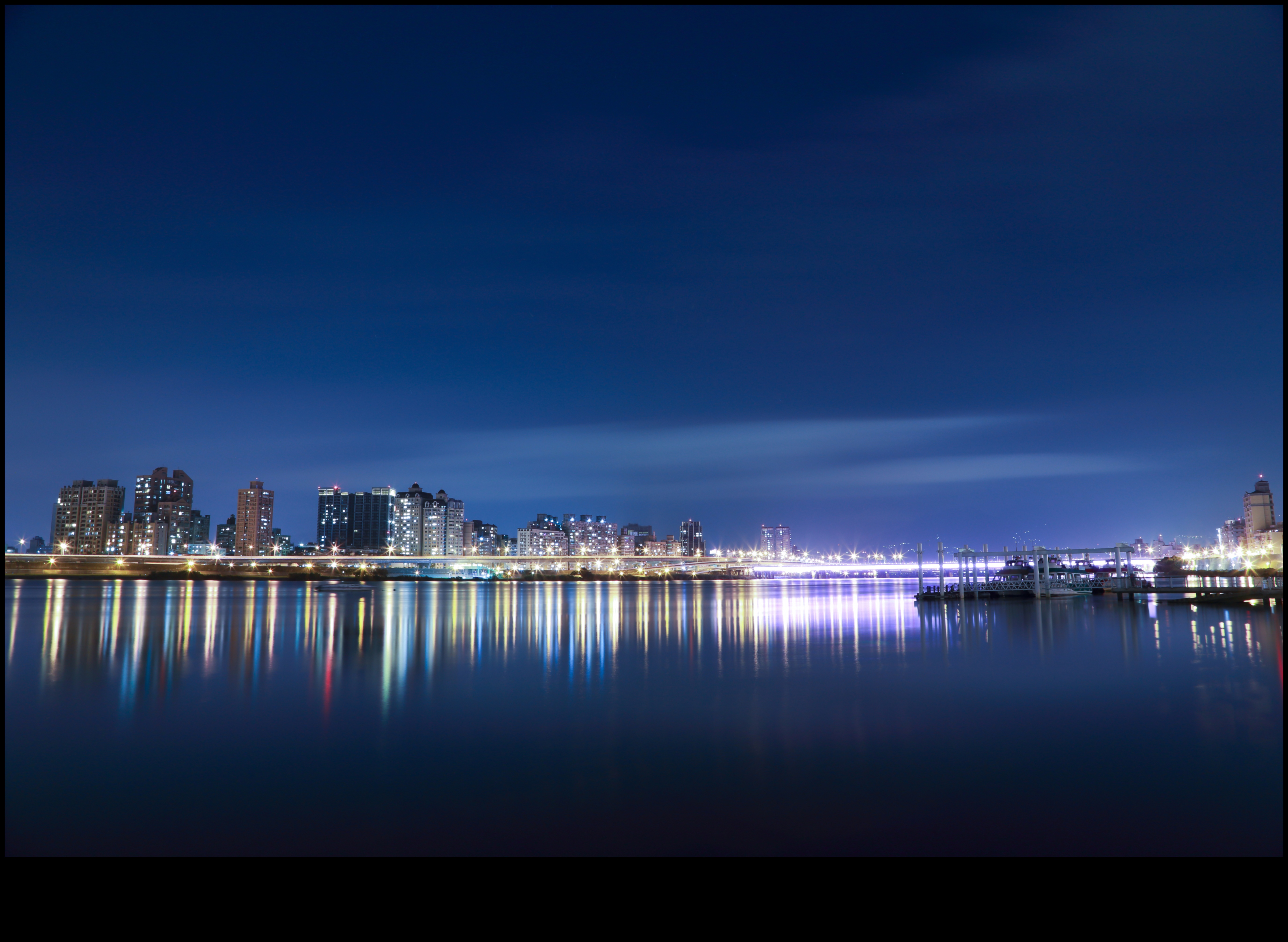 Nighttime Reflections: City Lights on Urban Waters